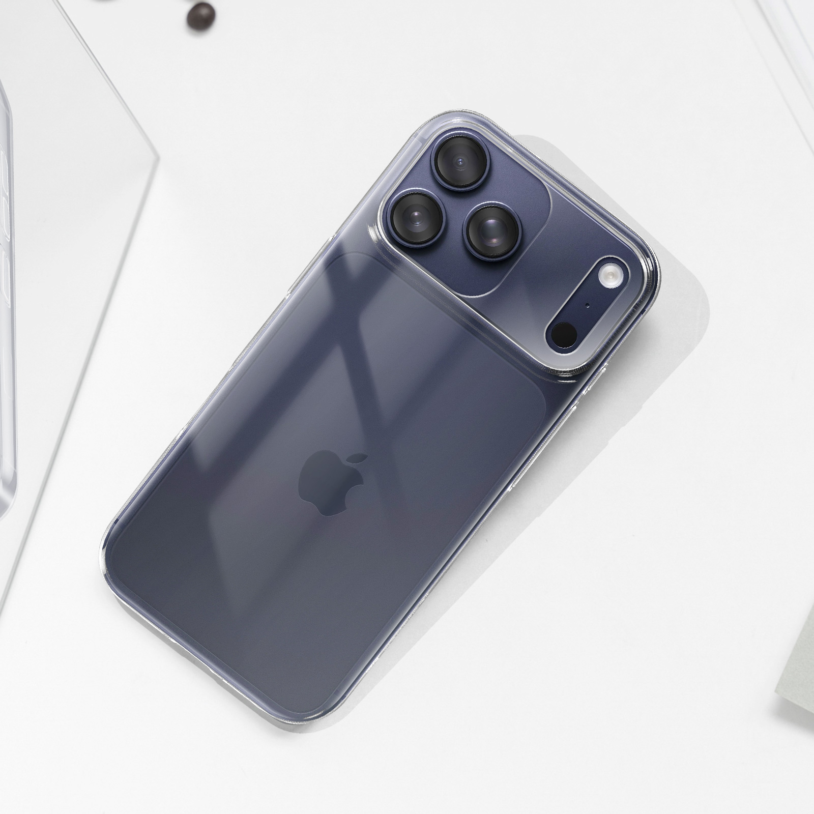 Uno smartphone scuro con tre fotocamere poggia su una superficie bianca.