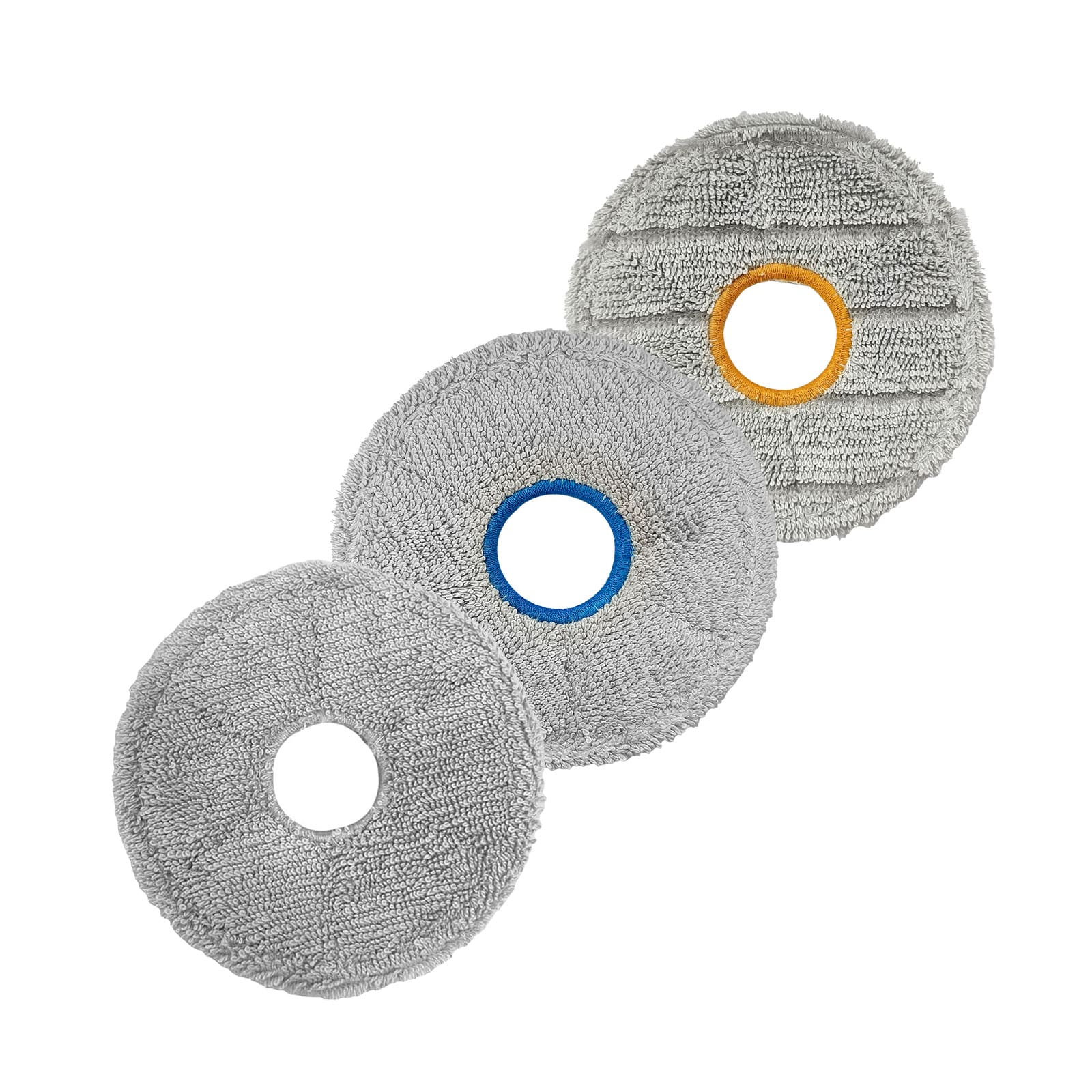 Drei graue Reinigungspads mit unterschiedlichen farbigen Ringen in der Mitte.