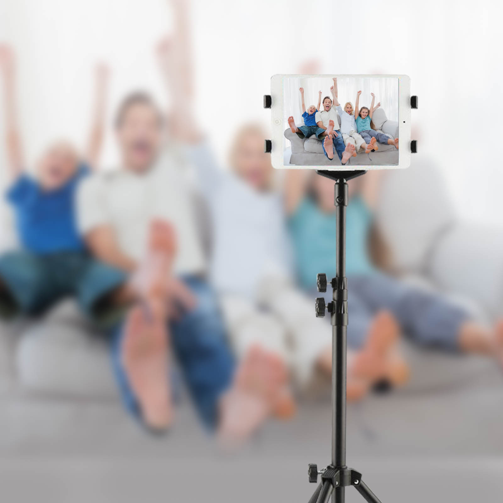 Famiglia esulta sul divano, filmata da un tablet su treppiede.