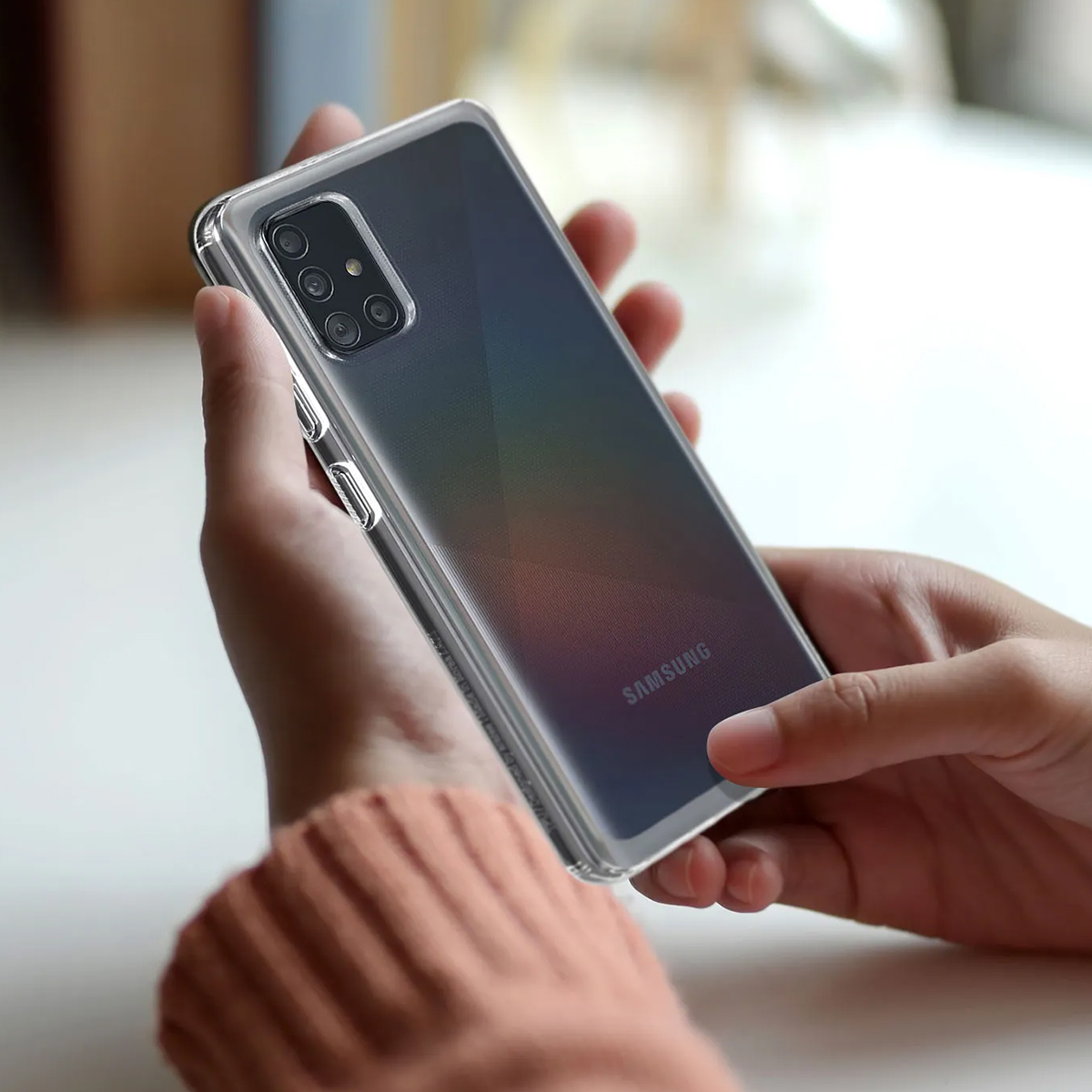 Mani che tengono un telefono Samsung in una custodia trasparente.