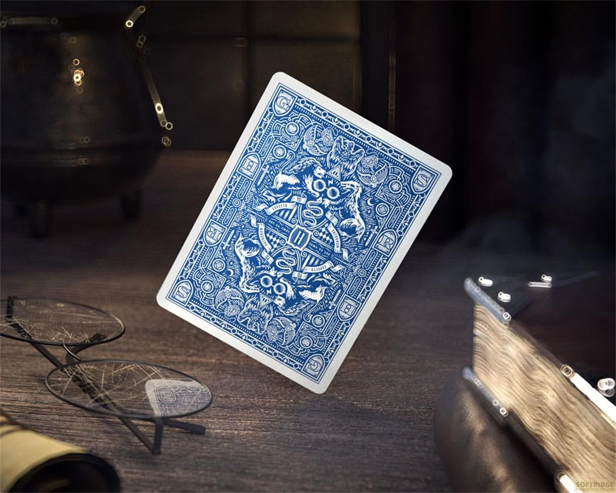 Una carta da gioco blu fantasia fluttua su un tavolo di legno con occhiali.