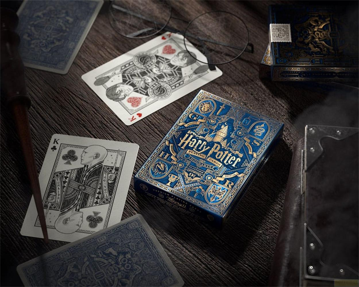 Carte da gioco di Harry Potter su tavolo di legno con occhiali, bacchetta e re.