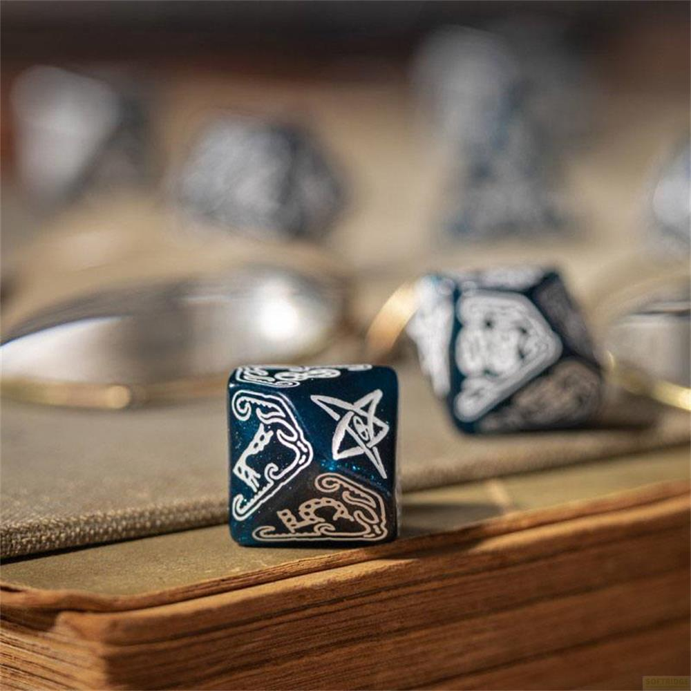 Dés bleu foncé avec des runes blanches sur un livre ouvert.