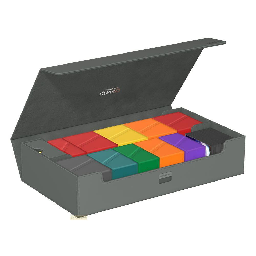 Boîte de rangement grise avec inserts colorés et piles de cartes.
