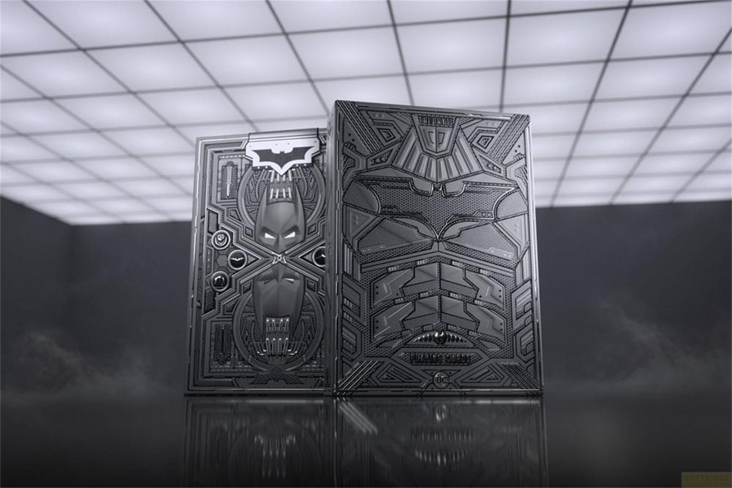 Deux jeux de cartes Batman aux motifs gaufrés complexes, présentés dans un décor sombre.