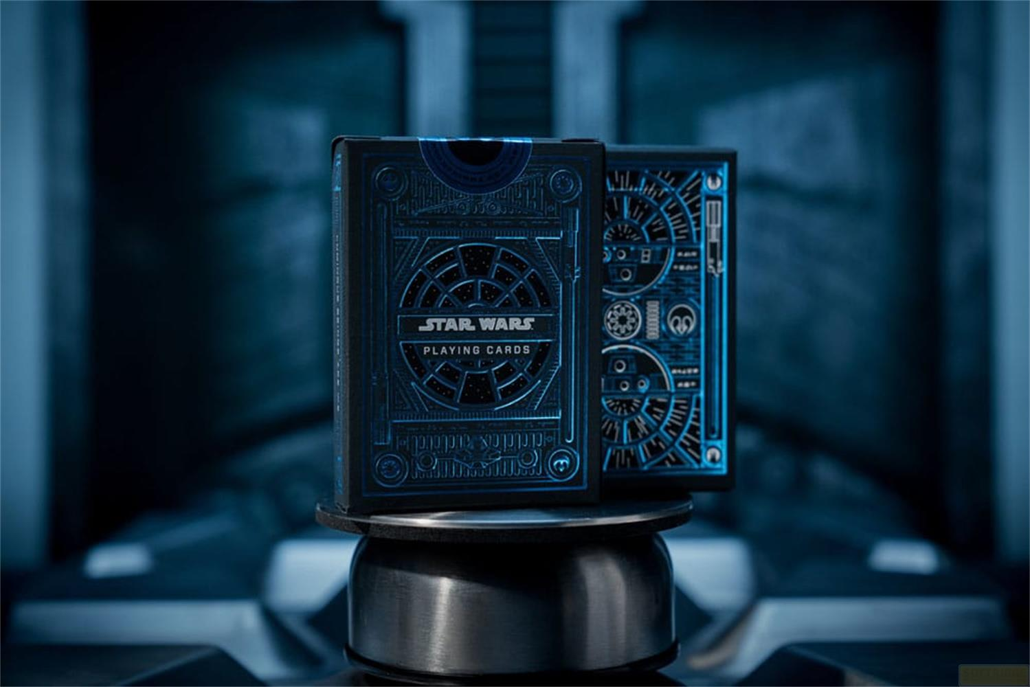 Deux boîtes de jeu de cartes Star Wars bleues à motifs géométriques se dressent sur un piédestal.