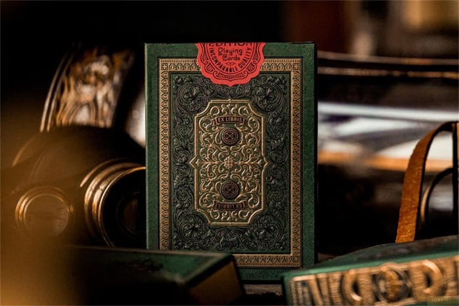 Boîte de cartes à jouer verte avec dorure et sceau rouge.