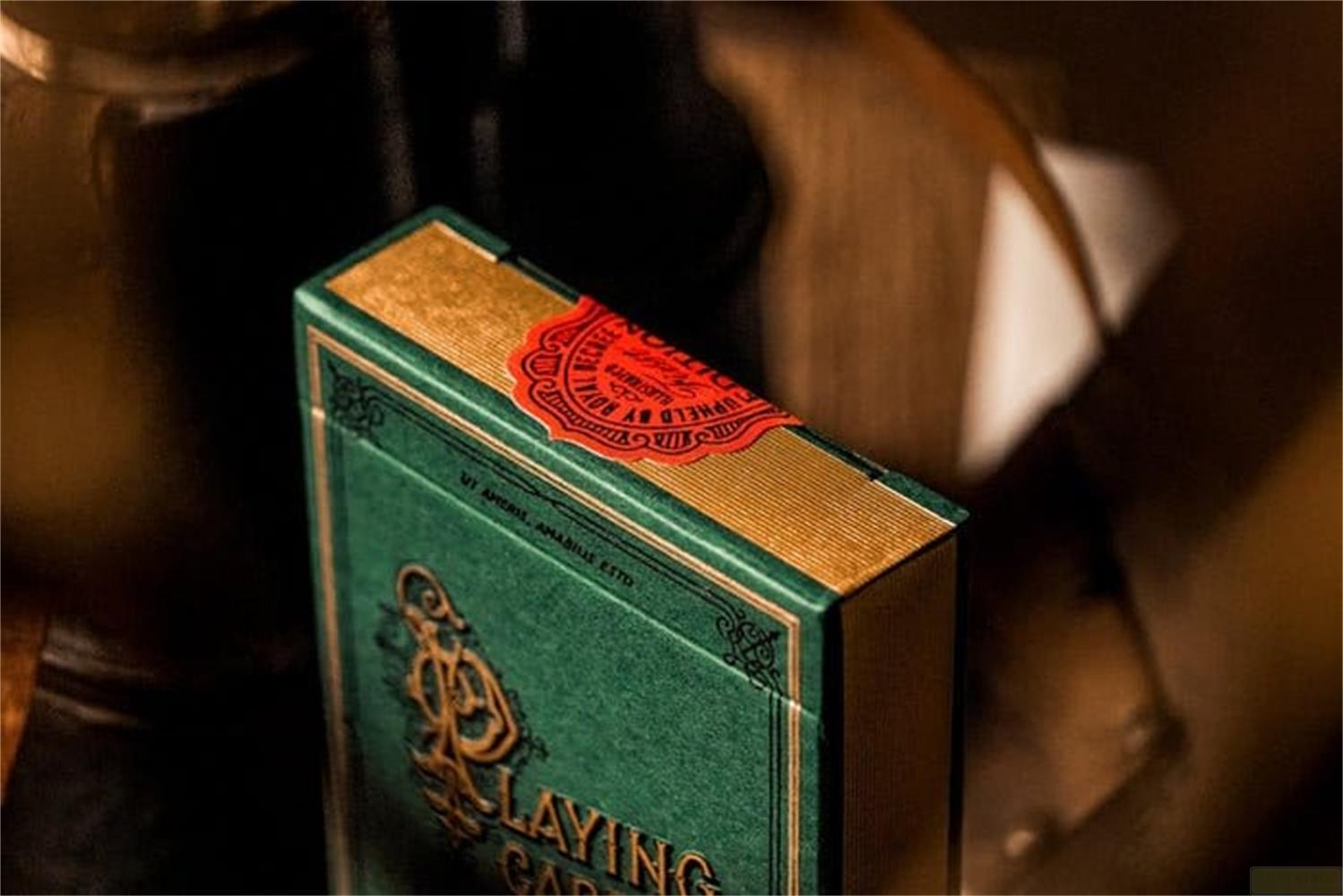 Boîte de jeu verte à bordure dorée et sceau rouge.
