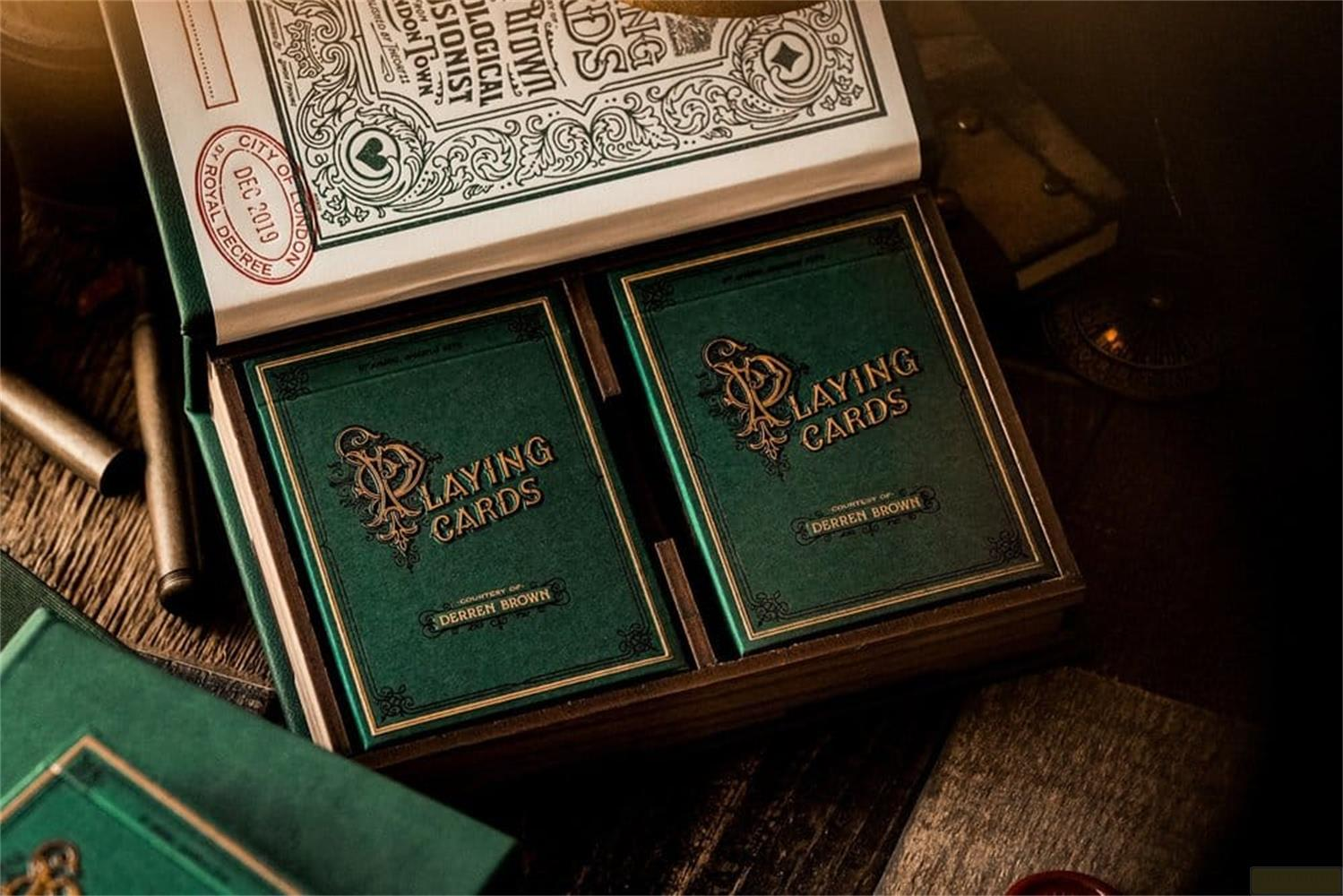 Deux jeux de cartes à jouer verts avec lettrage doré dans une boîte en bois.