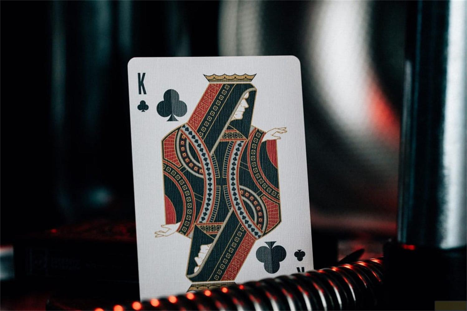 Carte à jouer Roi de Trèfle avec motif détaillé rouge et noir.