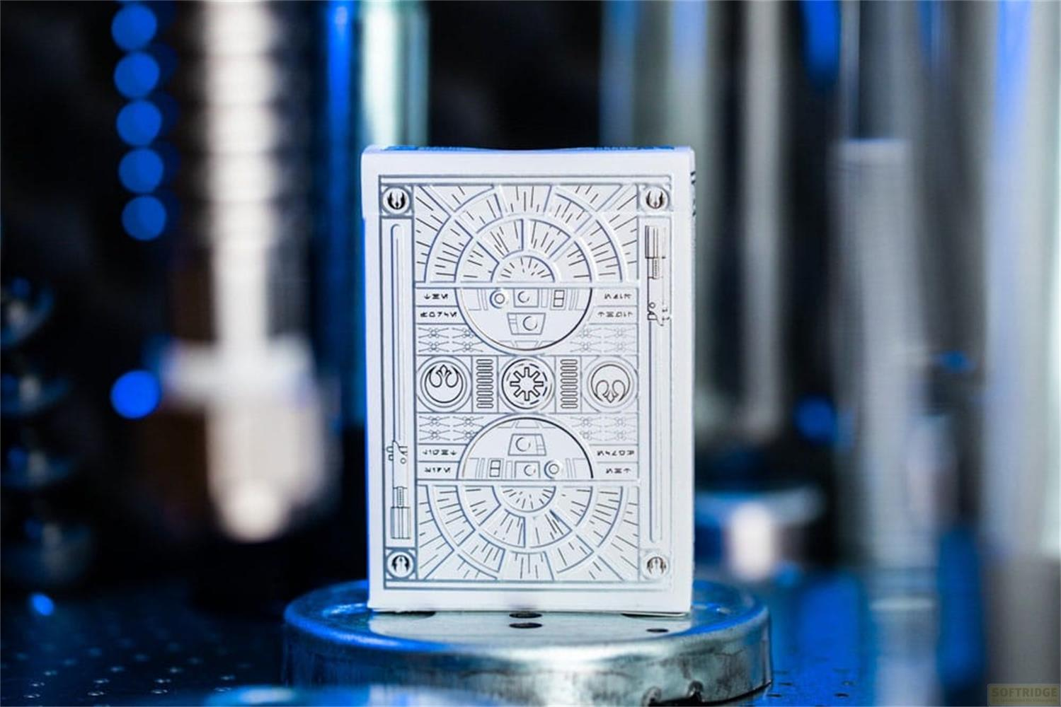 Un jeu de cartes blanc avec un design géométrique argenté, centré sur un piédestal.