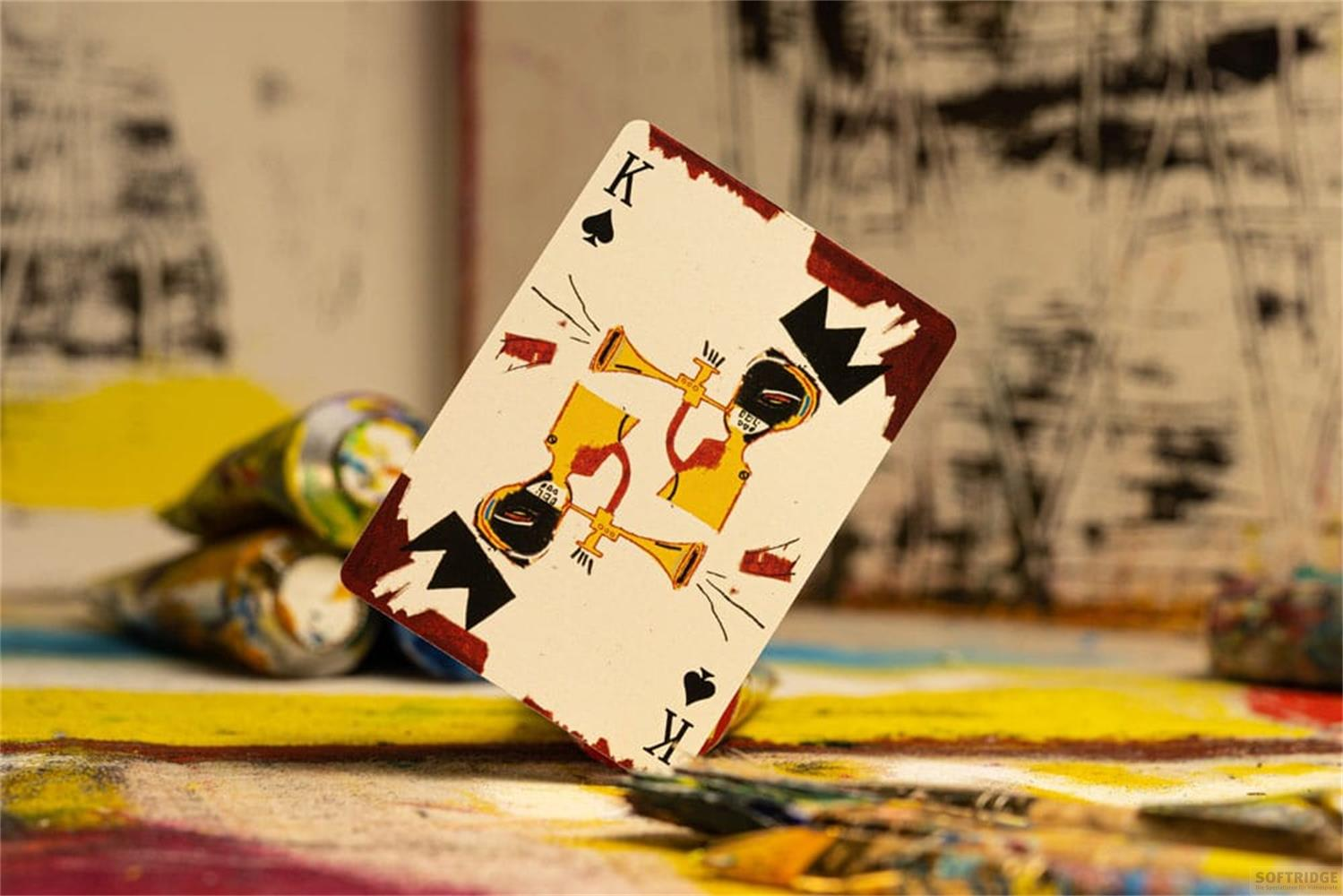 Carte à jouer Roi avec trompettes devant des tubes de peinture sur toile.