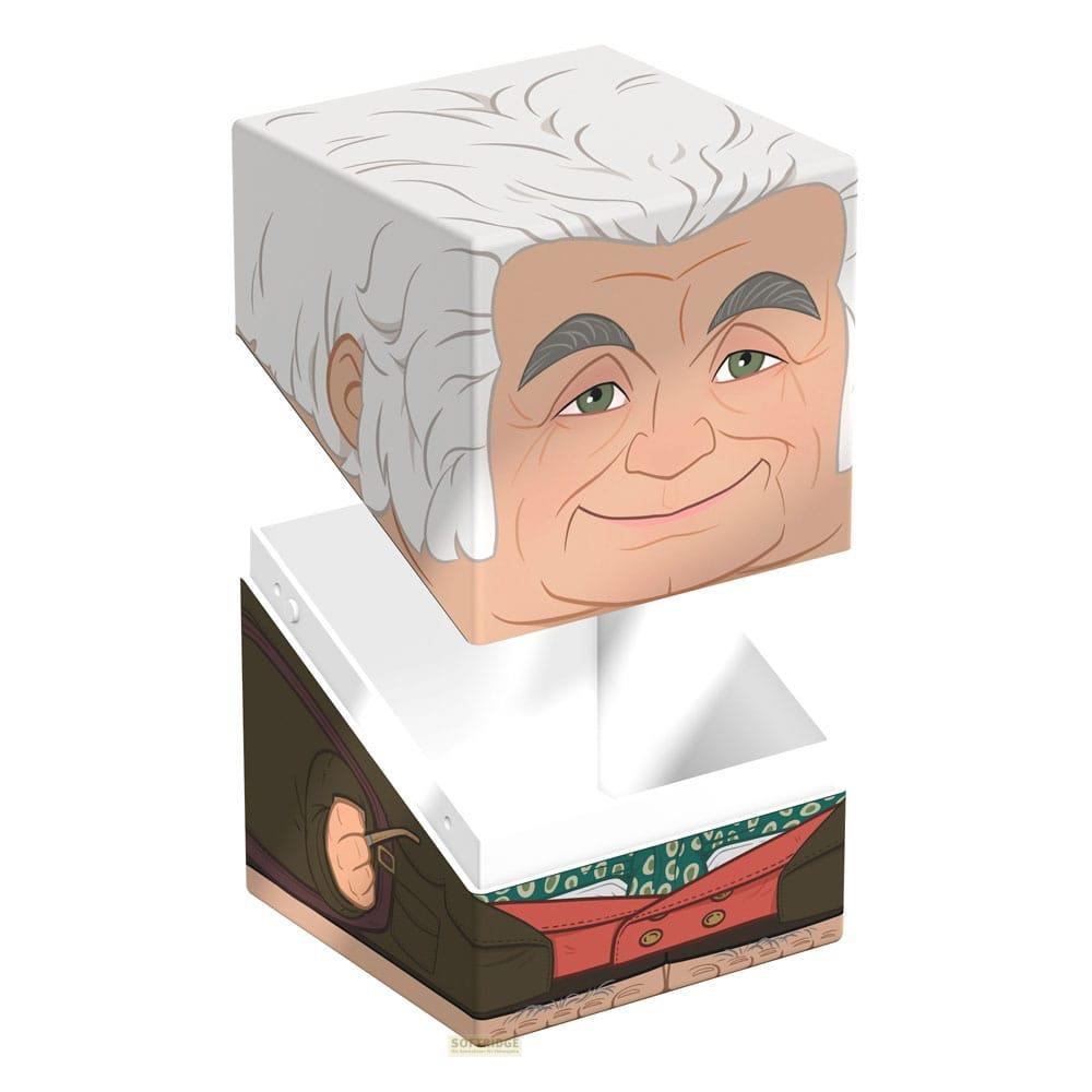 Un cube avec le visage d'un vieil homme repose sur une boîte ouverte montrant des détails de vêtements.