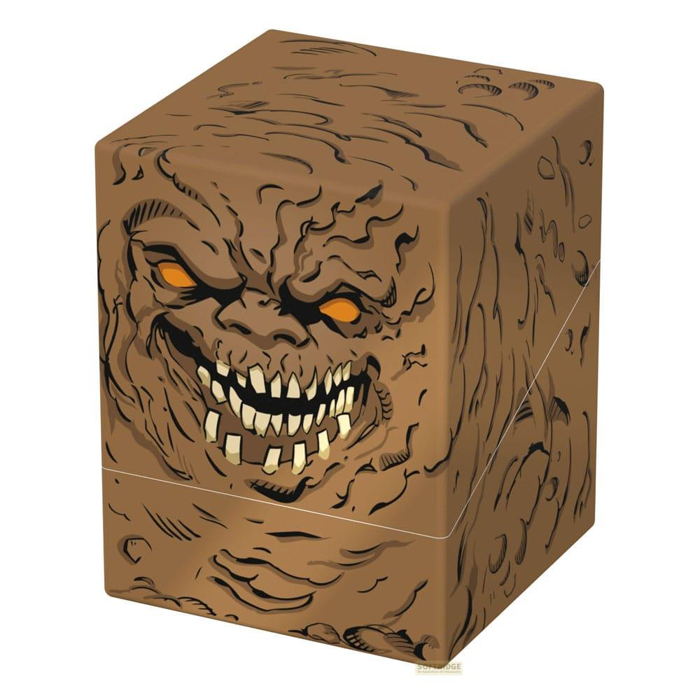 Braune Würfelbox mit gruseligem Gesicht, orangefarbenen Augen und spitzen Zähnen.