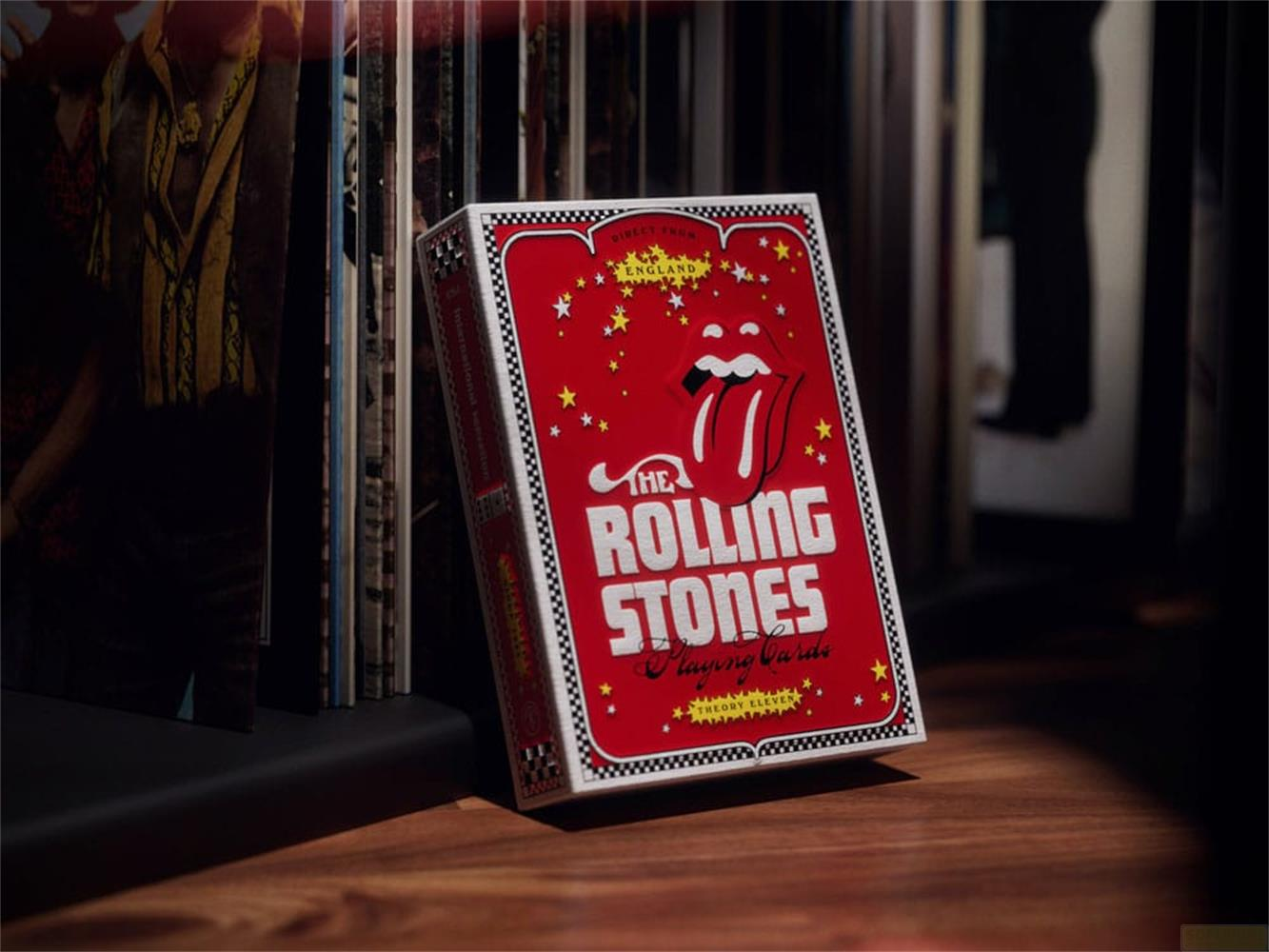 Rote Rolling Stones Spielkartenschachtel mit Zunge-Logo, neben Schallplatten.
