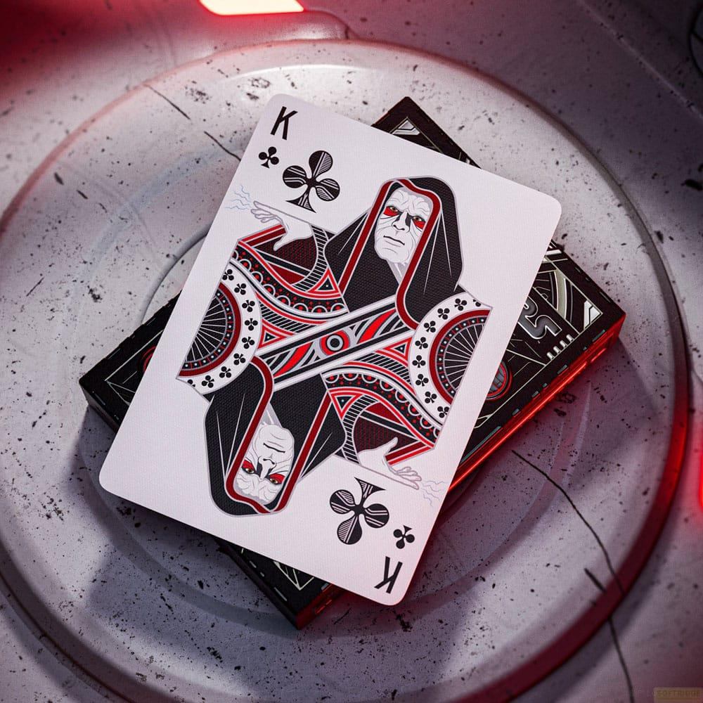 Ein Spielkartenkönig mit Kapuze und roten Augen, der auf einem Spielkartenschachtel liegt.