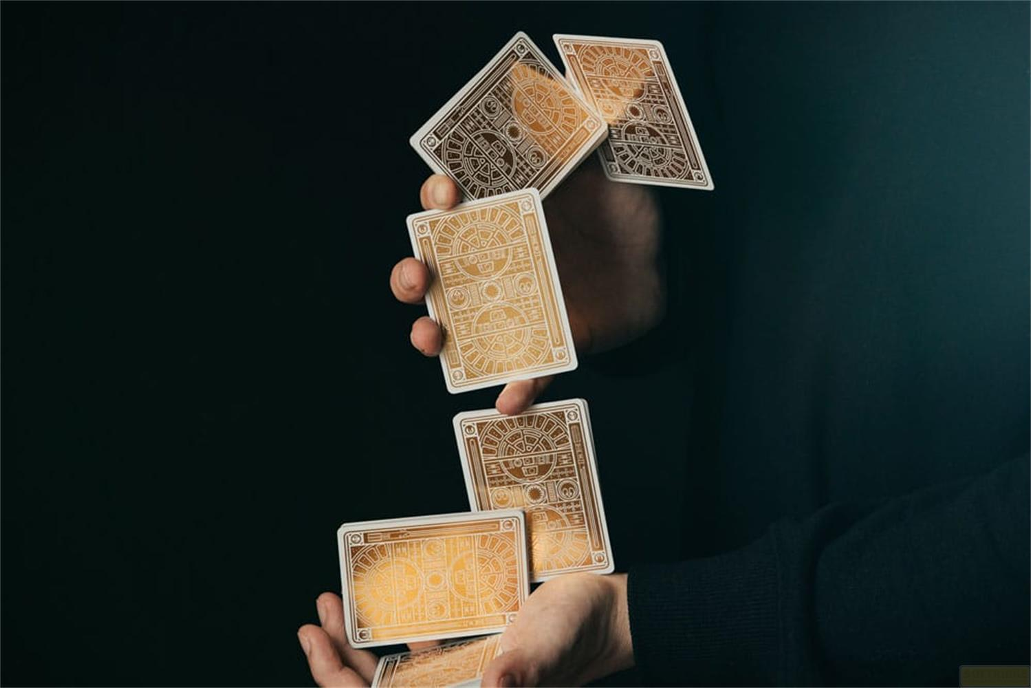 Carte da gioco dorate con motivi cadono su sfondo scuro.
