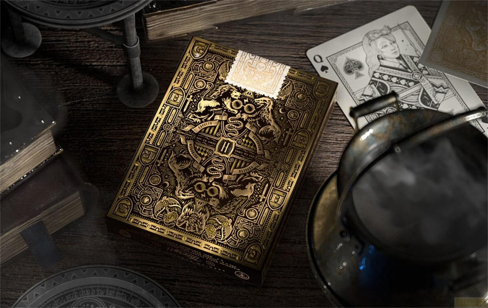 Ornata scatola di carte da gioco dorata, accanto a libri e una carta regina.