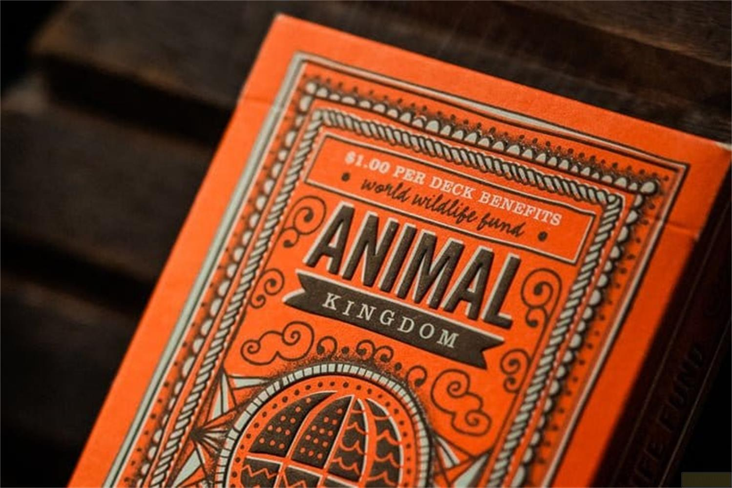 Scatola di carte da gioco arancione con stampa "Animal Kingdom" e globo.