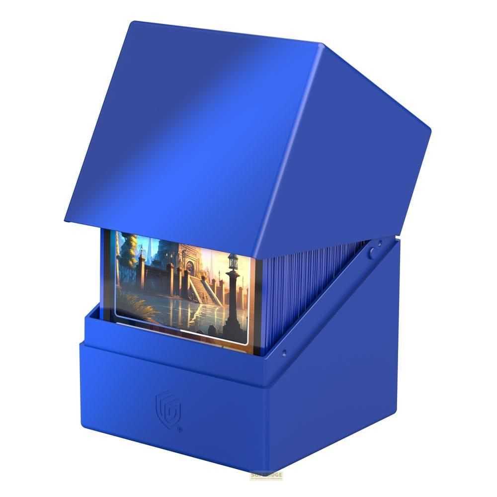 Boîte à cartes bleue avec couvercle ouvert révélant un paysage urbain sur des cartes.