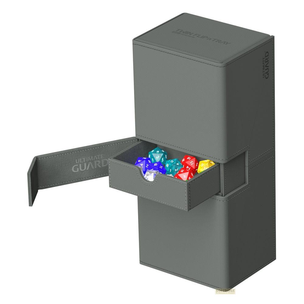 Graue Aufbewahrungsbox mit Schublade, die bunte Würfel enthält. Ultimate Guard Logo sichtbar.