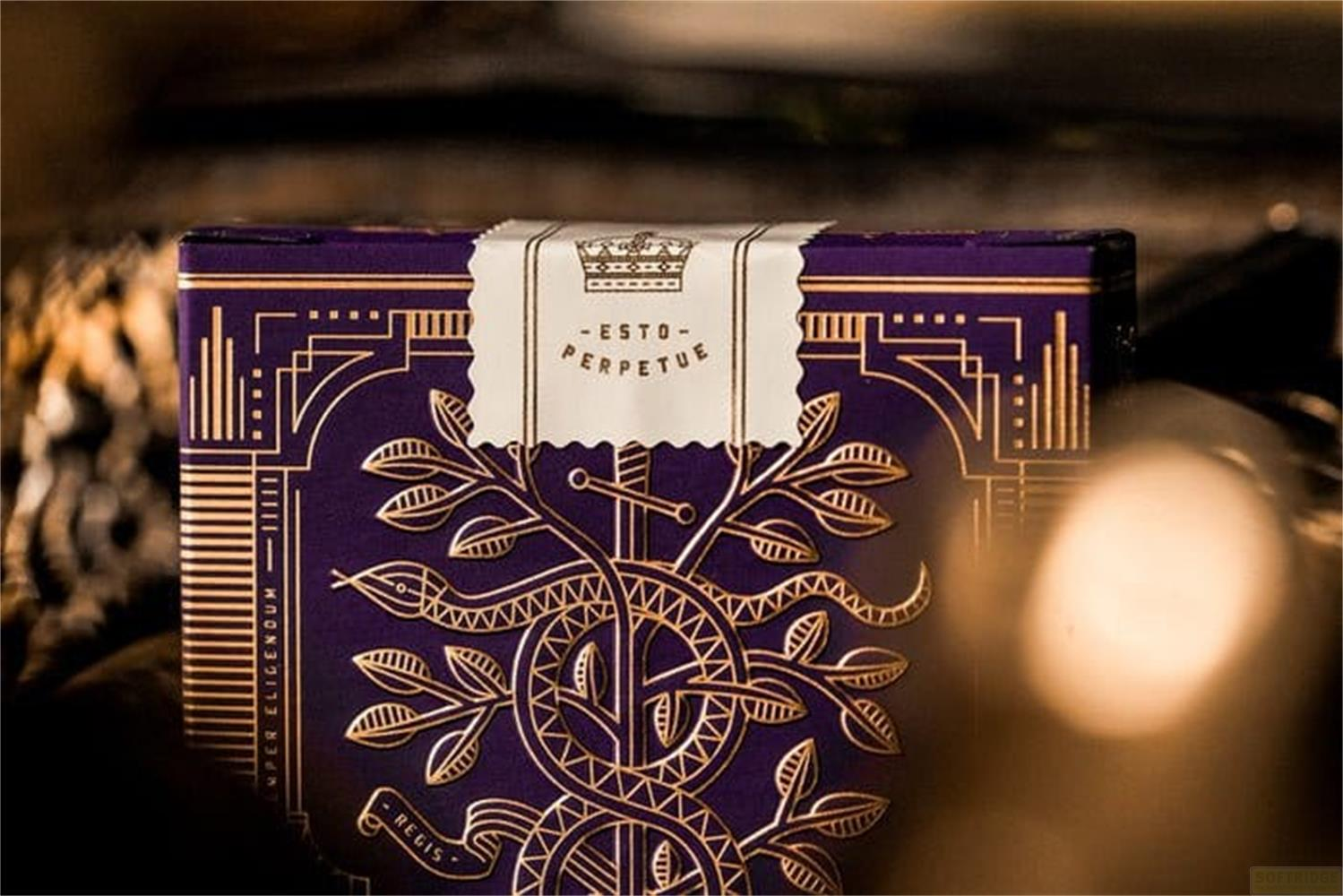 Un mazzo di carte viola con ornamenti dorati, raffigurante un ramo di alloro e una corona.