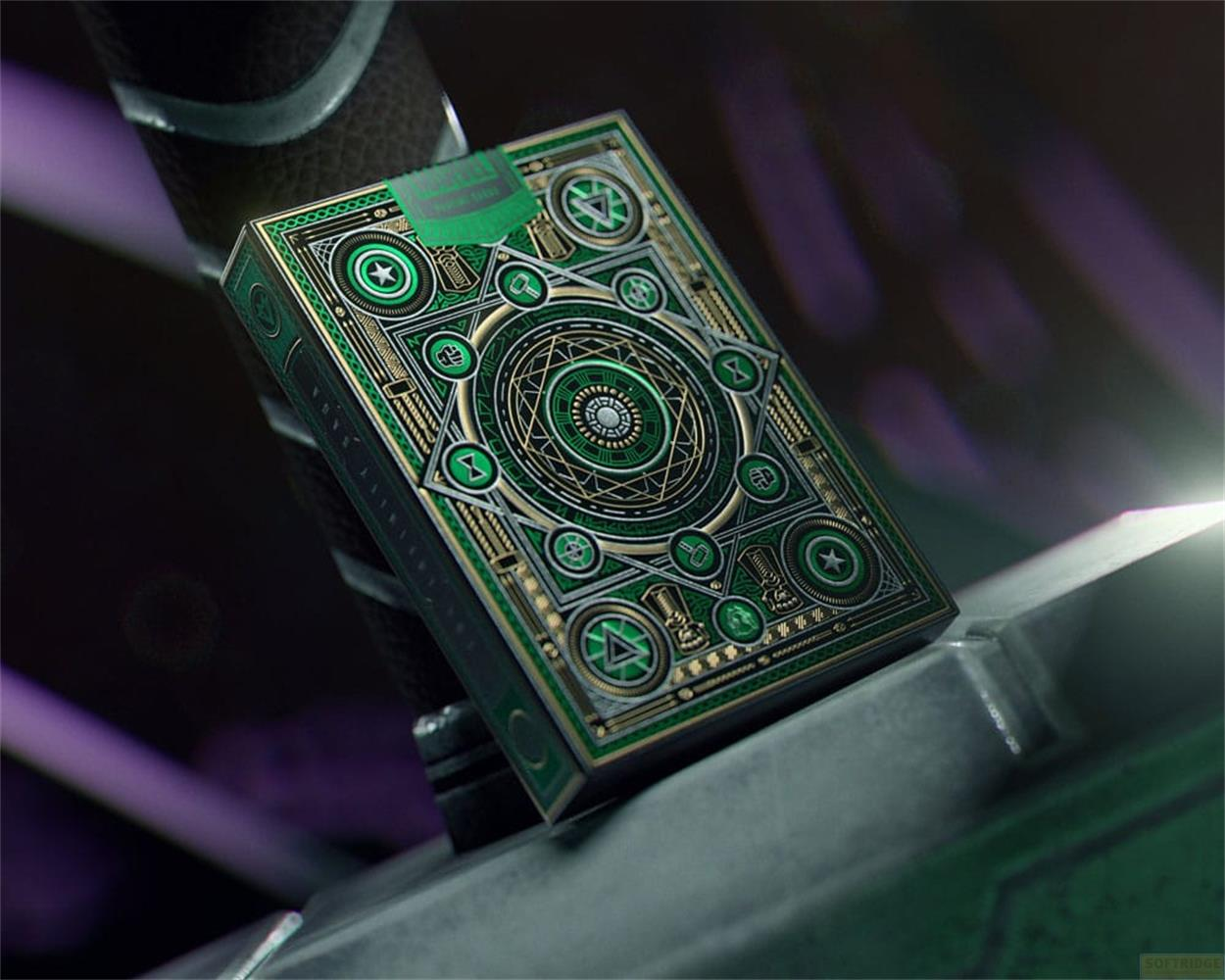 Carta da gioco verde con simboli oro e argento poggia su un oggetto grigio.