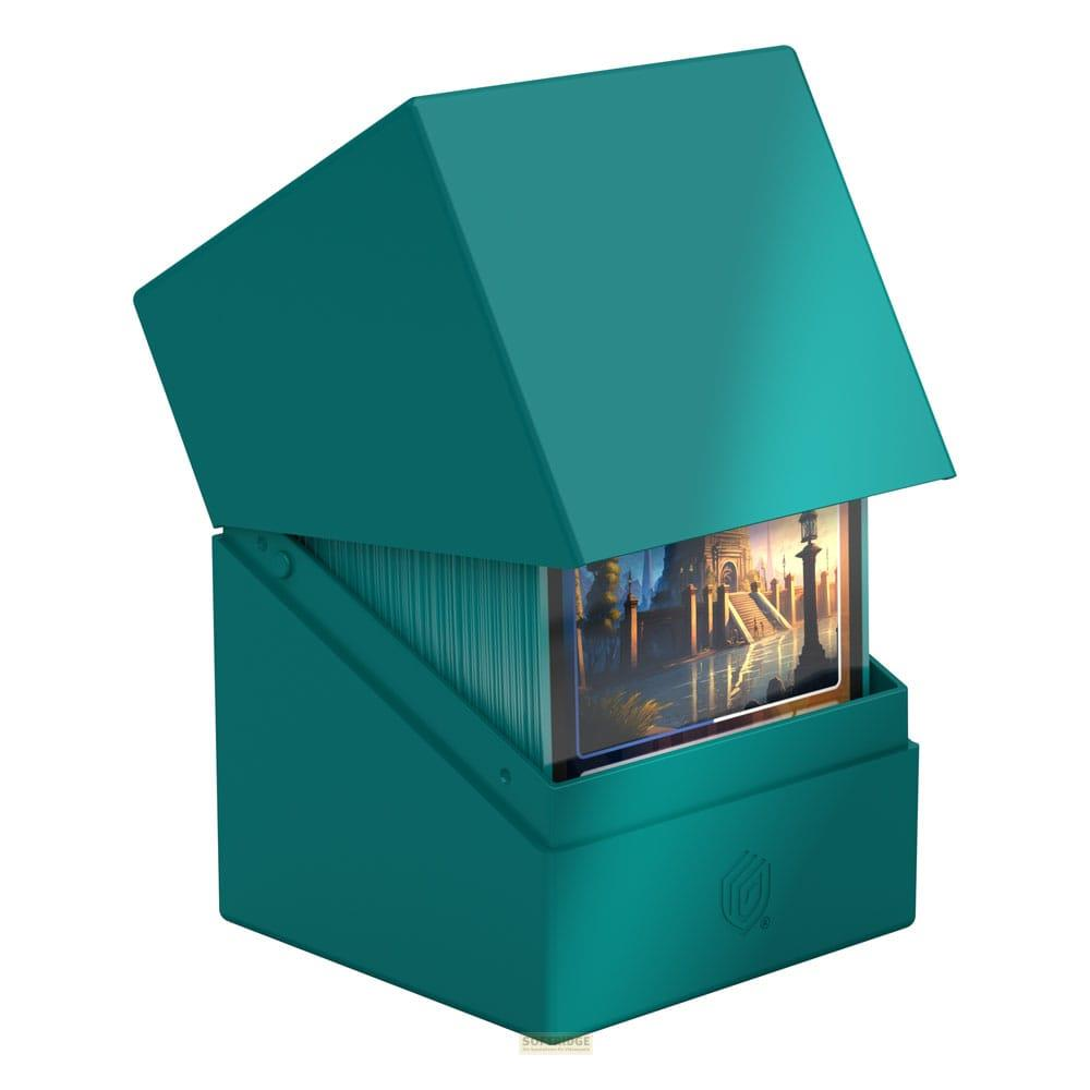 Un porta carte color ottanio con coperchio aperto, pieno di carte da gioco.