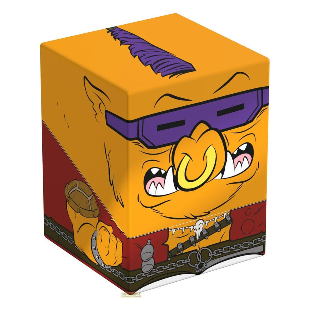 Scatola arancione con volto mostro cartoon, occhiali viola, naso giallo, gioielli.