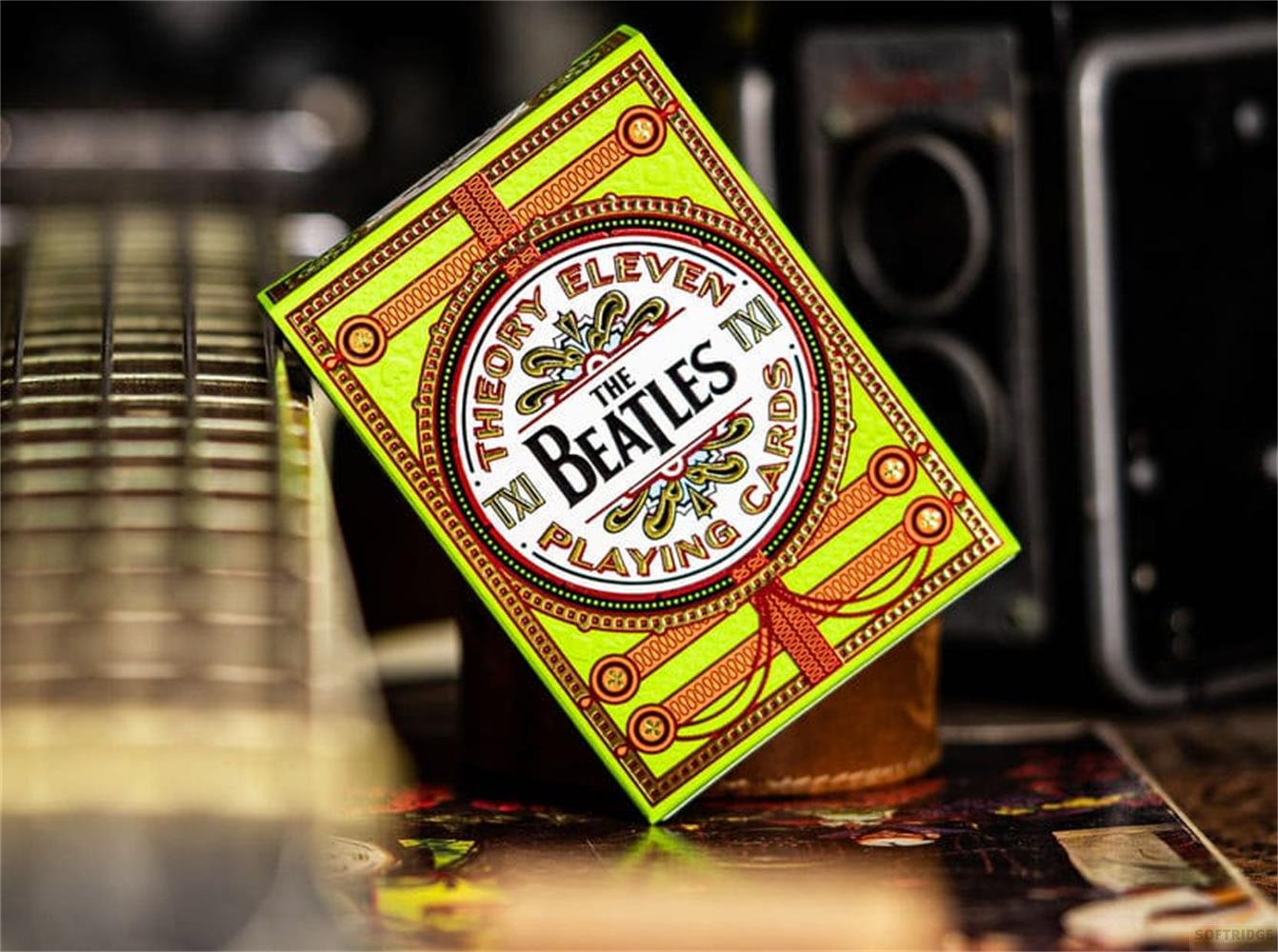 Una scatola di carte da gioco verde neon con logo "The Beatles" su un tavolo.