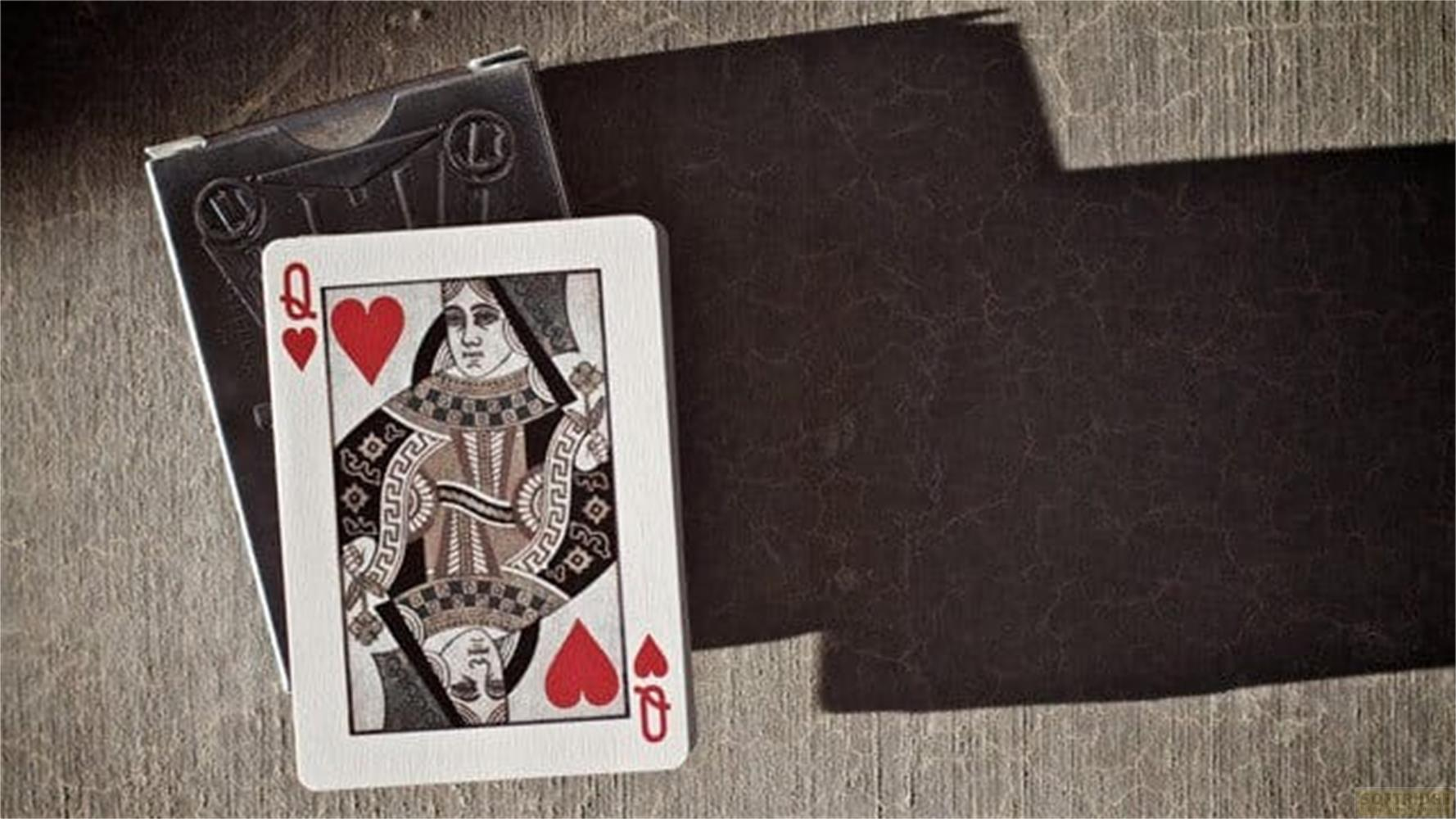 Carta da gioco Regina di Cuori con scatola nera su tavolo legno.