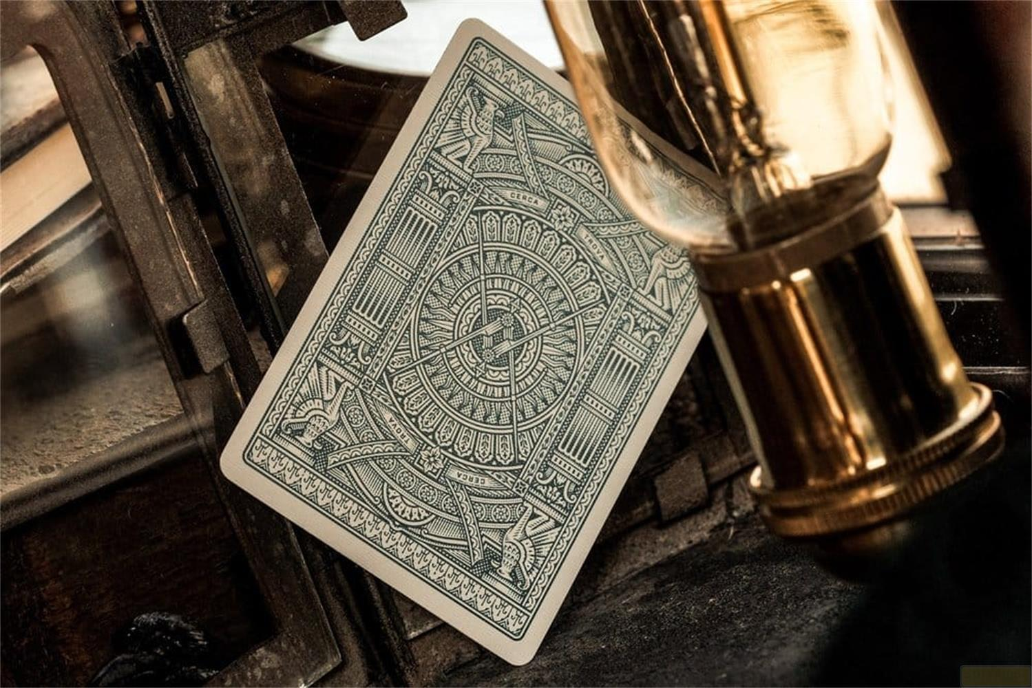 Una carta da gioco con motivo dettagliato giace accanto a una lampadina.