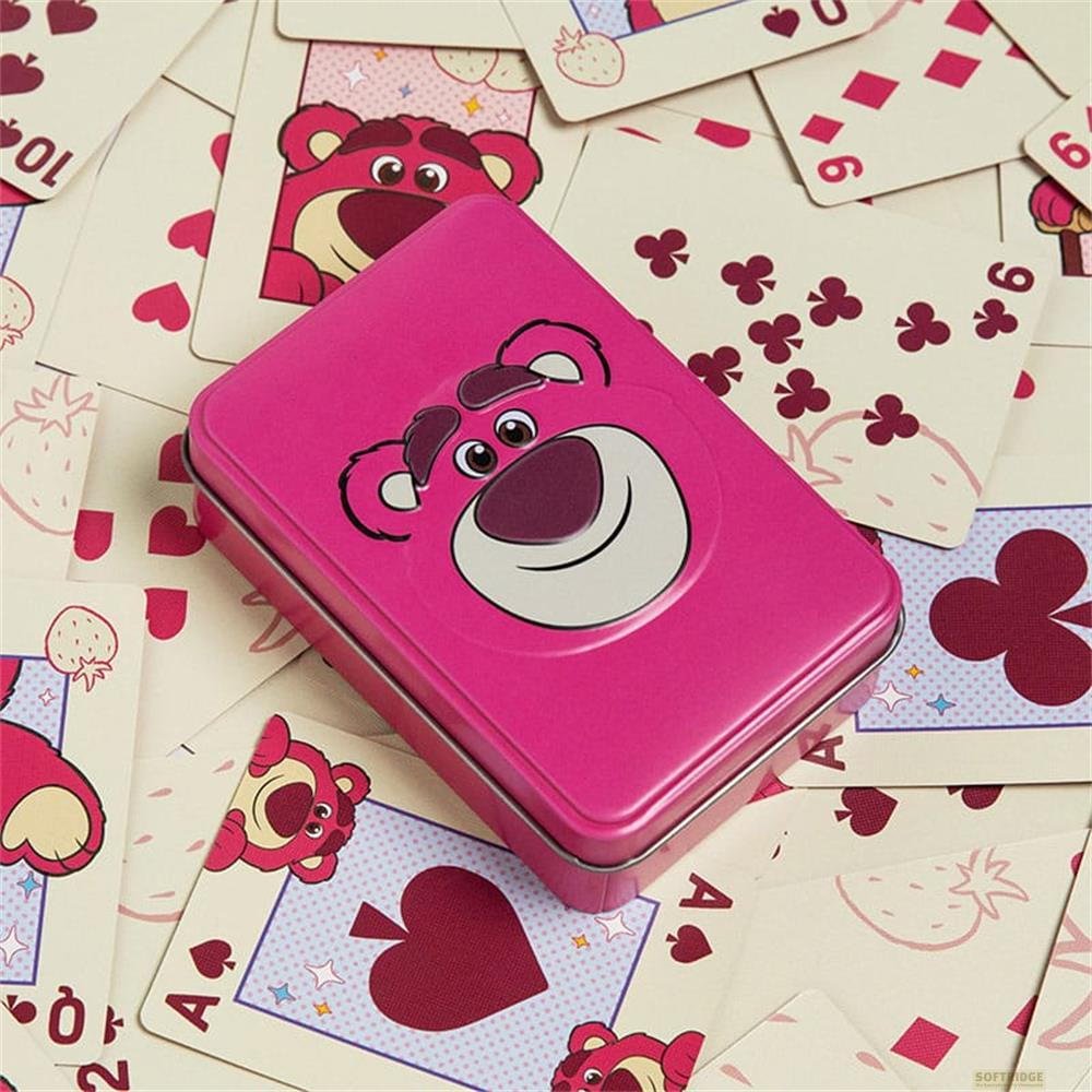 Une boîte rose avec le design de Lotso Ours repose sur des cartes.