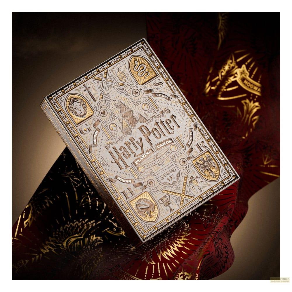 Une boîte de cartes à jouer Harry Potter avec des détails dorés sur du tissu rouge.