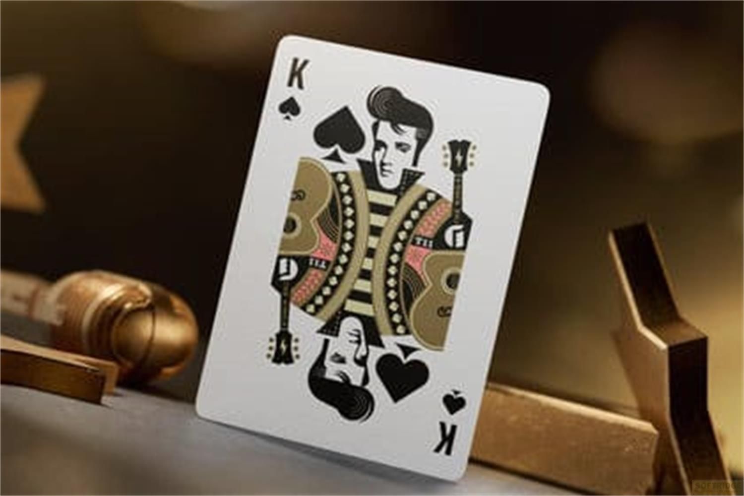 Una carta Re con design di Elvis, circondata da oggetti dorati.