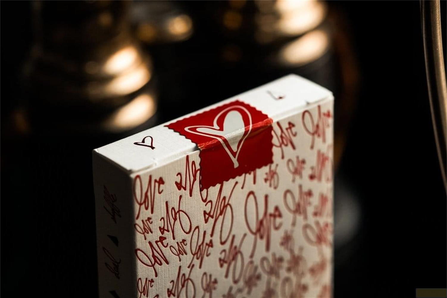 Un cofanetto bianco per carte con simboli rossi di cuore e amore, a fuoco.