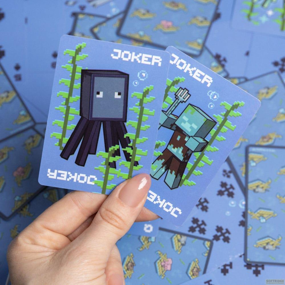 Une main tient deux cartes Joker Minecraft avec un calamar et un zombie.