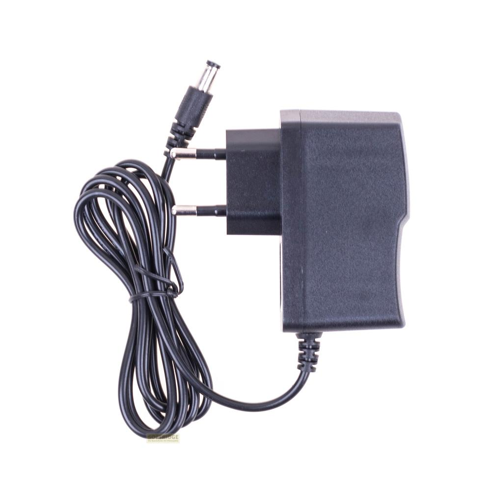 Ein schwarzes Netzteil mit einem gewickelten Kabel und einem Stecker.