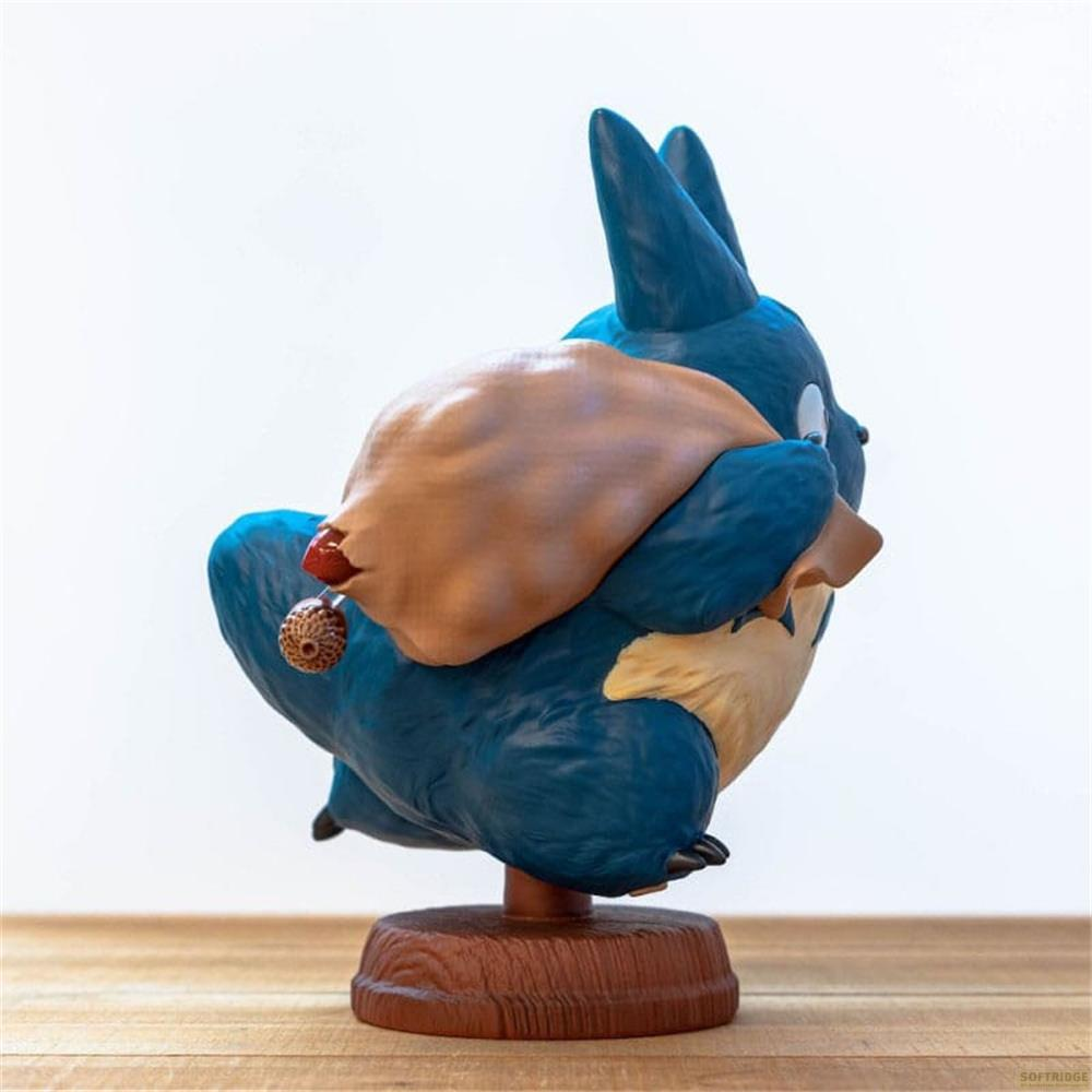 Una statuetta blu con un sacco marrone sulla schiena, su una base marrone.