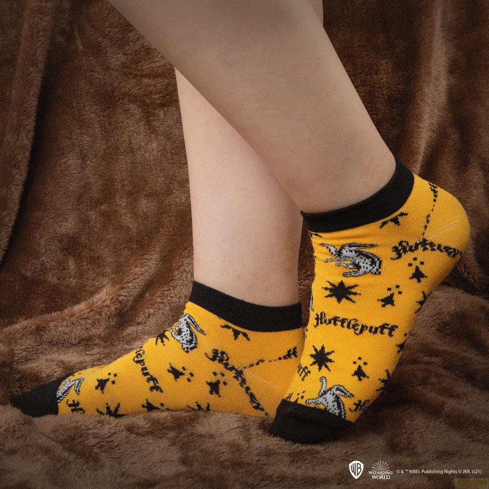 Gelbe Socken mit schwarzem Bündchen und Hufflepuff-Motiv.