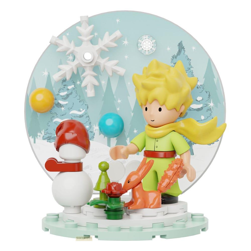 Eine kleine Figur des Prinzen mit einem Schneemann und einem Hasen vor Bäumen.