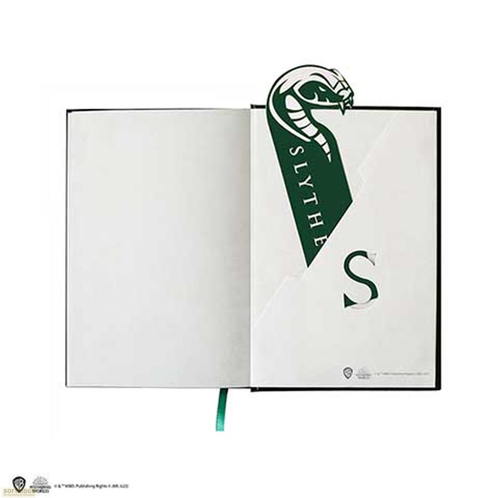 Ein Slytherin-Schlangen-Lesezeichen ragt aus einem offenen Notizbuch.