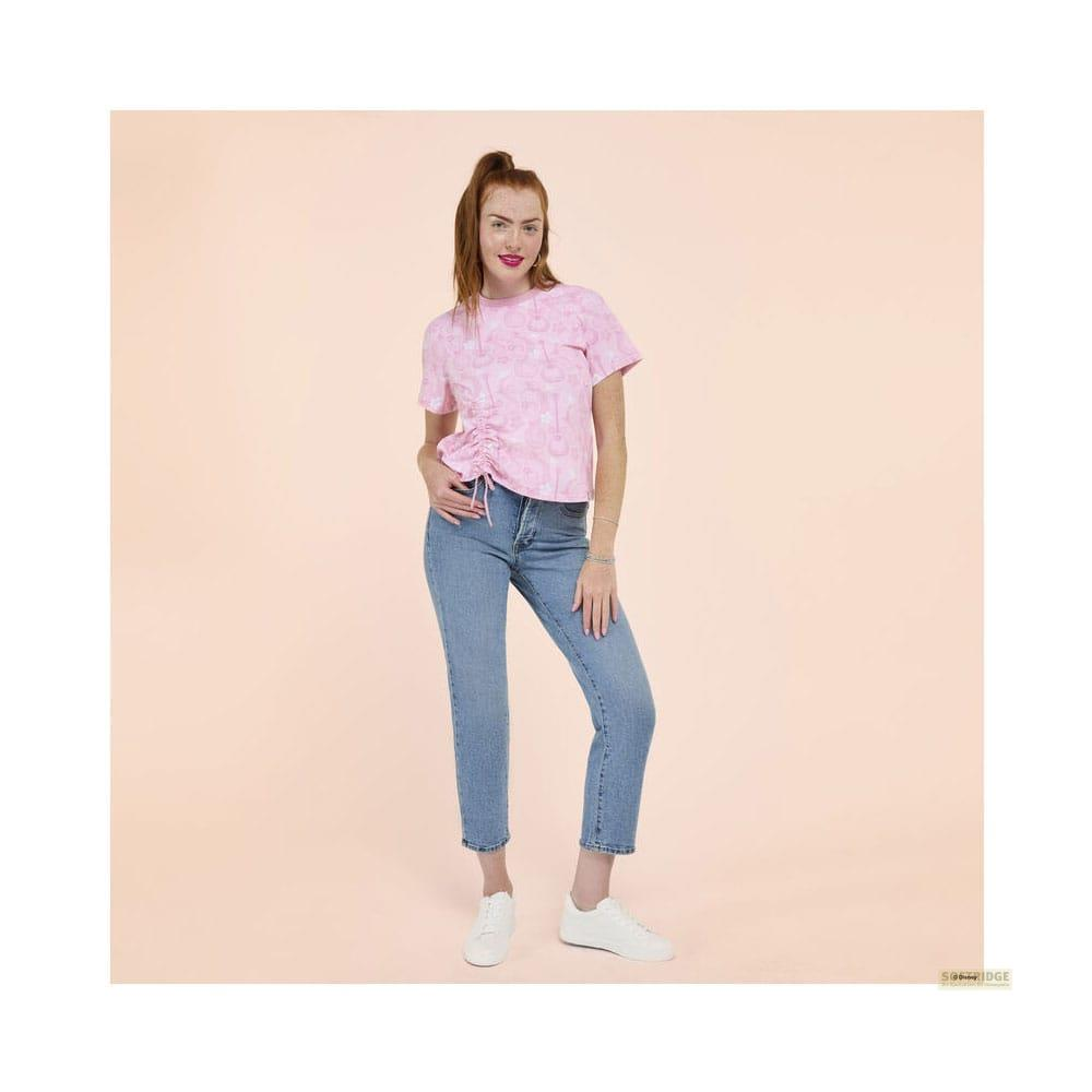 Eine Frau mit roten Haaren trägt ein rosafarbenes Oberteil und Jeans.