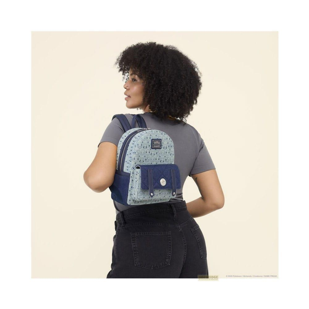 Mujer con mochila azul con estampado de Pokémon, jeans y camiseta gris.
