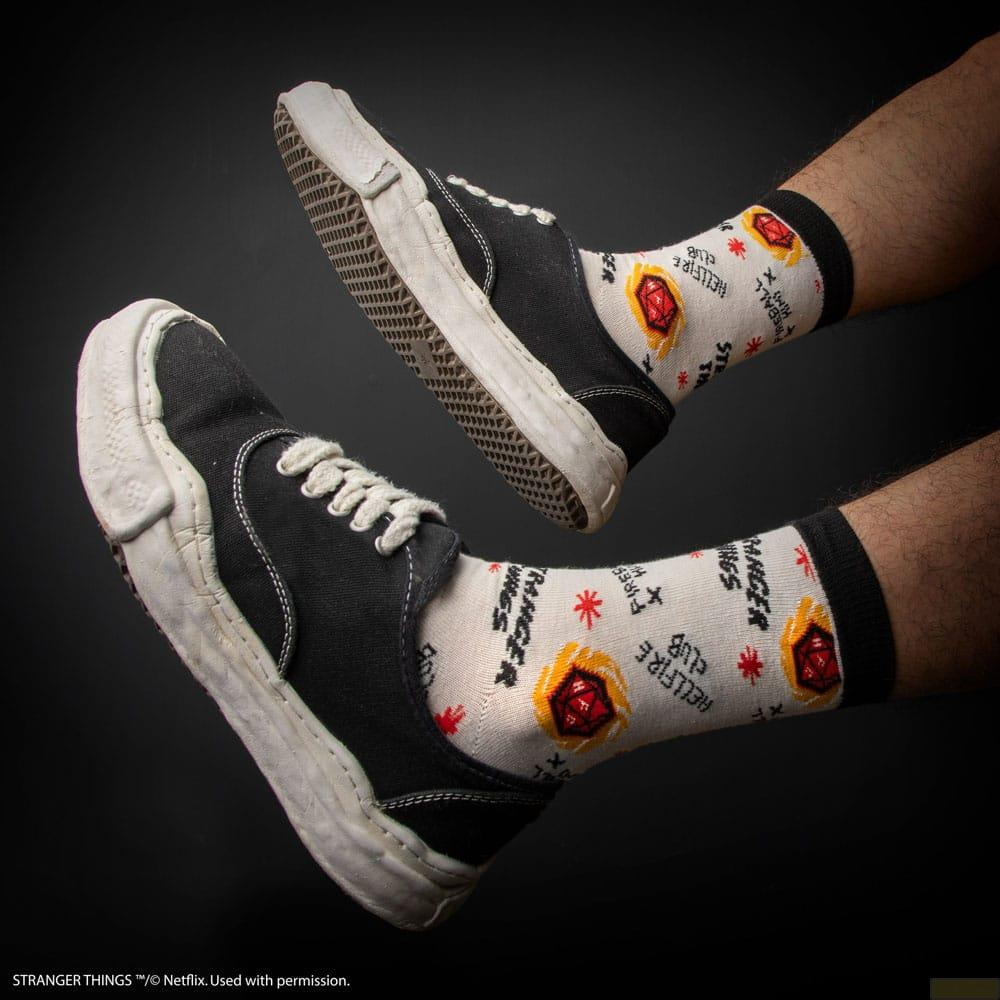 Baskets noires et chaussettes blanches avec des dés rouges et des imprimés de feu sur fond noir.