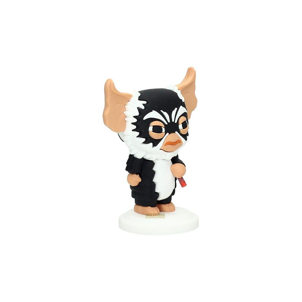 Una pequeña figura de un gremlin con pelo negro, blanco y marrón, sosteniendo un cigarro rojo.