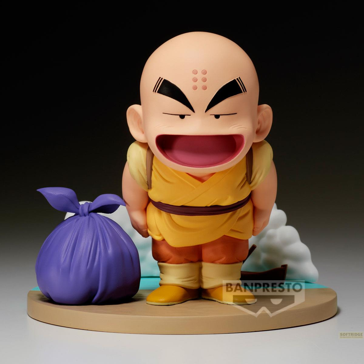 Figura de Krilin con bolsa morada sobre base, ante cielo azul y nubes.