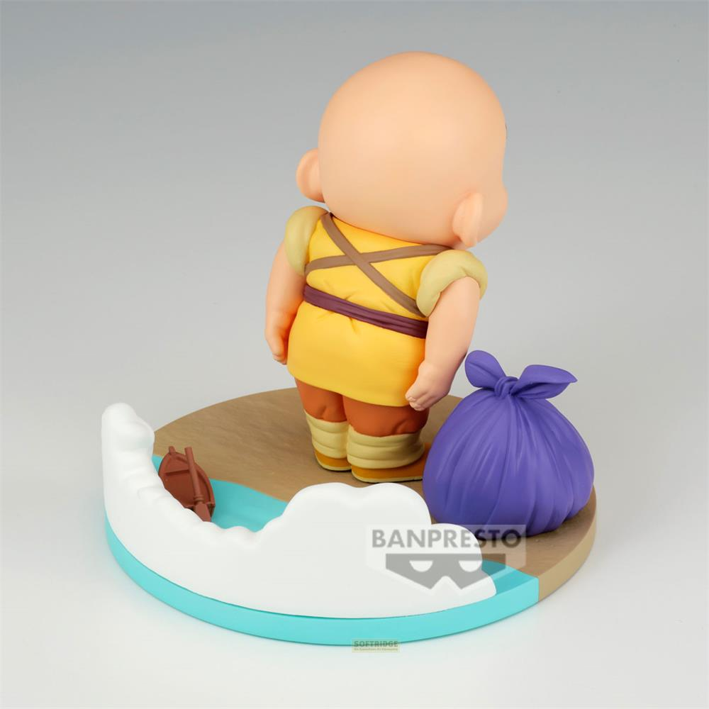 Una figura de anime calva con camisa amarilla junto a una bolsa morada.