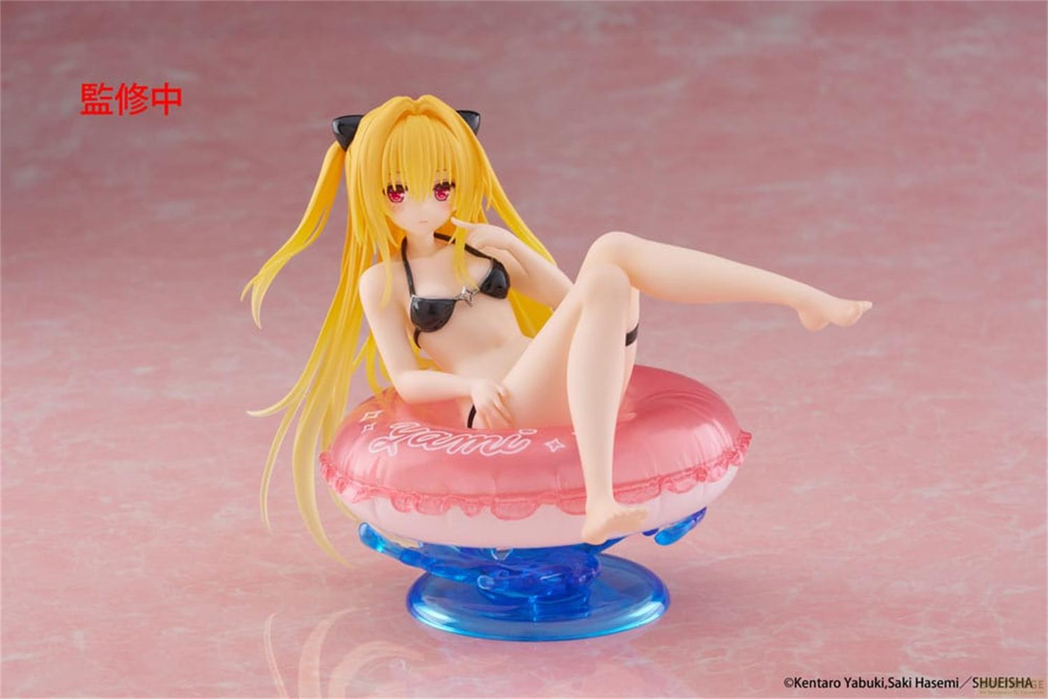 Eine Figur eines Anime-Mädchens mit blonden Haaren in einem schwarzen Bikini auf einem rosa Schlauchboot.