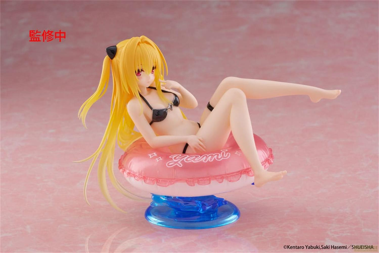 Eine Figur mit gelben Haaren im Bikini sitzt auf einem rosafarbenen Schwimmring.